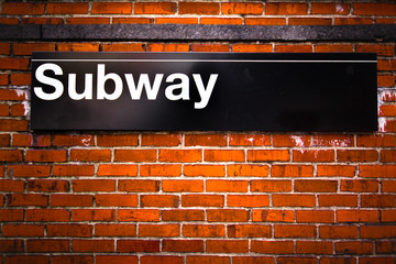 Obraz premium New York City subway sign entrance on brick wall