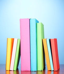 Fototapeta na wymiar Stack of multicolor books on blue background