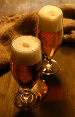 Glasses of beer on wooden table close-up