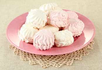 Marshmallows on color plate on light background