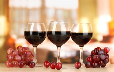 Red wine in glass on room background