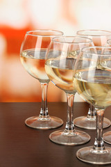 White wine in glass on room background