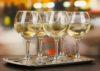 White wine in glass on room background