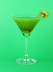 Green juice in coctail glass on green background