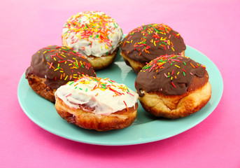 Tasty donuts on color plate on color background