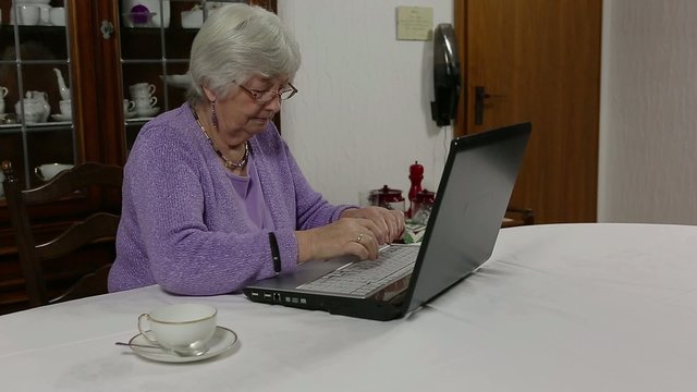 Rentnerin tippt an Laptop