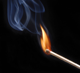 Encendiendo un cerillo,fósforo encendido en fondo negro.