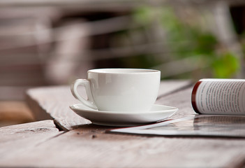 White cup with magazine on the wood table