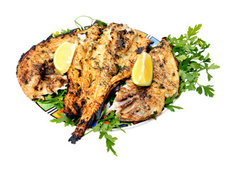 Grilled fish with greens on the plate - isolated on white backgr