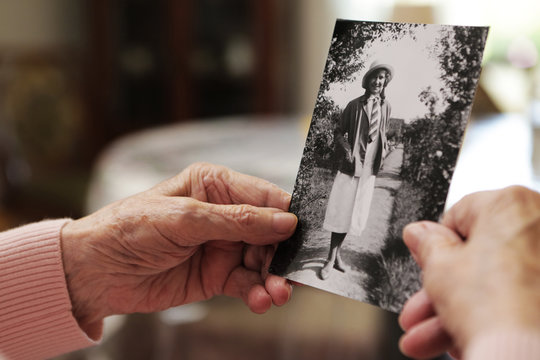 Seniorin mit altem Foto aus ihrer jugend 