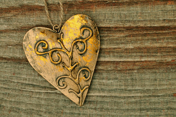 Goldenes Herz aus Metall auf Holzhintergrund