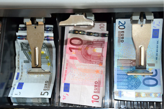 Billetes de cinco, diez y veinte euros en caja registardora.