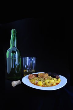 Pote de berzas con botella de sidra.