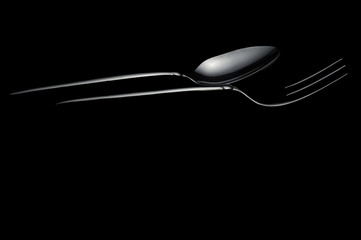 Silver metal spoon and fork on the black background