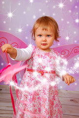 adorable baby girl with fairy wings and wand