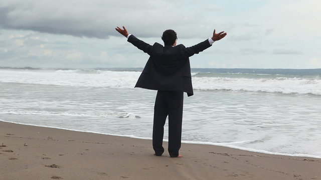 man in official suit standing on the sea coast
