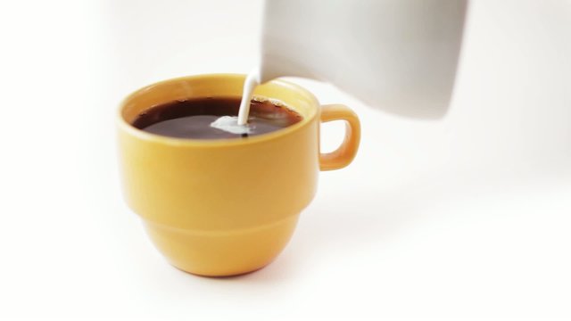 Pouring Creamer into Yellow Coffee Cup