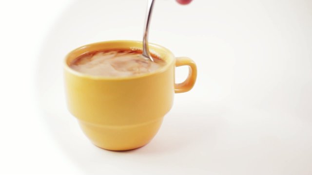 Stirring Creamer in Yellow Coffee Cup