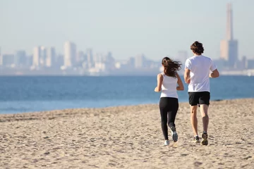 Papier Peint photo autocollant Jogging Man and woman running in the beach