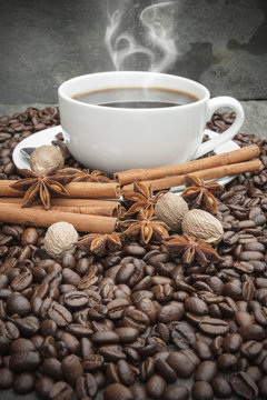 Steaming hot Cup of coffee with cinnamon, star anise, nutmeg and