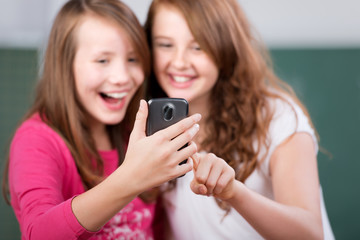 mädchen in der schule schauen auf ihr handy