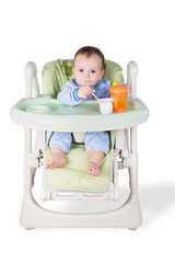 child is eating sitting at table, isolated over white