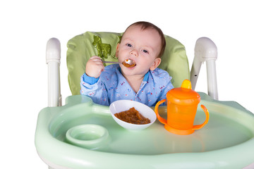 child is eating sitting at table, isolated over white