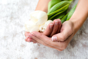 Flowers and female hands with manicure