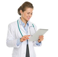 Happy medical doctor woman using tablet PC