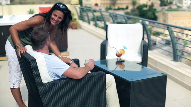 Happy couple with exotic drinks relaxing on the terrace, crane s