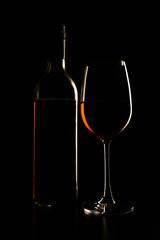 Bottle and glass with rose wine served on the table