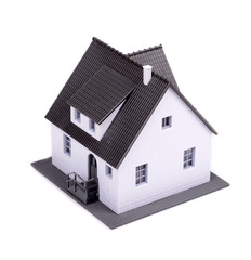 A model of house with dark roof on a white background.