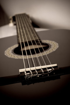 black acoustic guitar close up in sepia