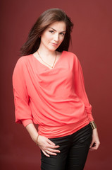 Young beautiful dark-haired woman on red background