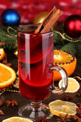 Fragrant mulled wine in glass with spices and oranges around