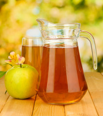Full glass and jug of apple juice and apple