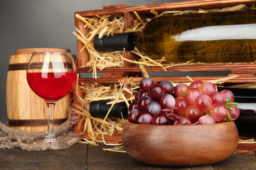 Wooden case with wine bottles, barrel, wineglass and grape