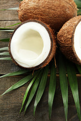 Coconut with leaves, on grey wooden background