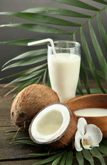 Coconut with glass of milk,  on wooden table, on grey