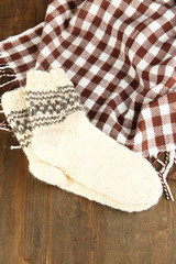 Warm knitted socks on wooden table close-up