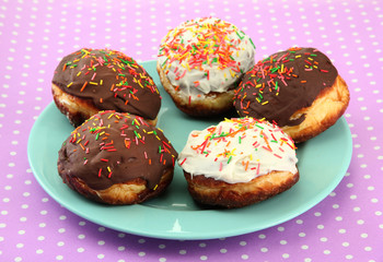 Tasty donuts on color plate on color background