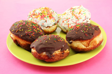 Tasty donuts on color plate on color background