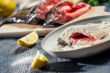 Close-up of fresh fish dipped in flour and seasoned with lemon