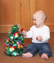 baby boy playing with christmas tree