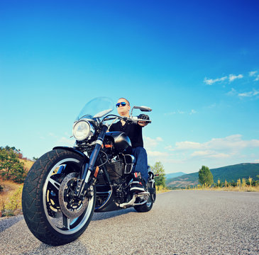 Biker Riding A Customized Motorcycle On An Open Road