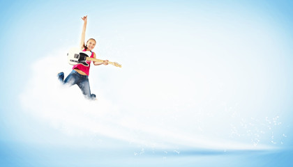 young woman playing on electro guitar and jumping