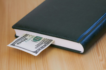 Hundred dollar bill lying in the notebook