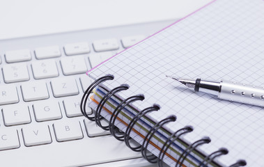 Notizbuch, Füllhalter und Tastatur