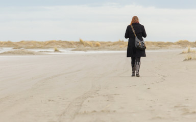 Lonely woman walking on a beach