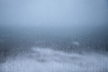 Rainy Holiday? Raindrops on window pane - sea background